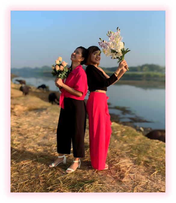 Women holding flowers by the lake
